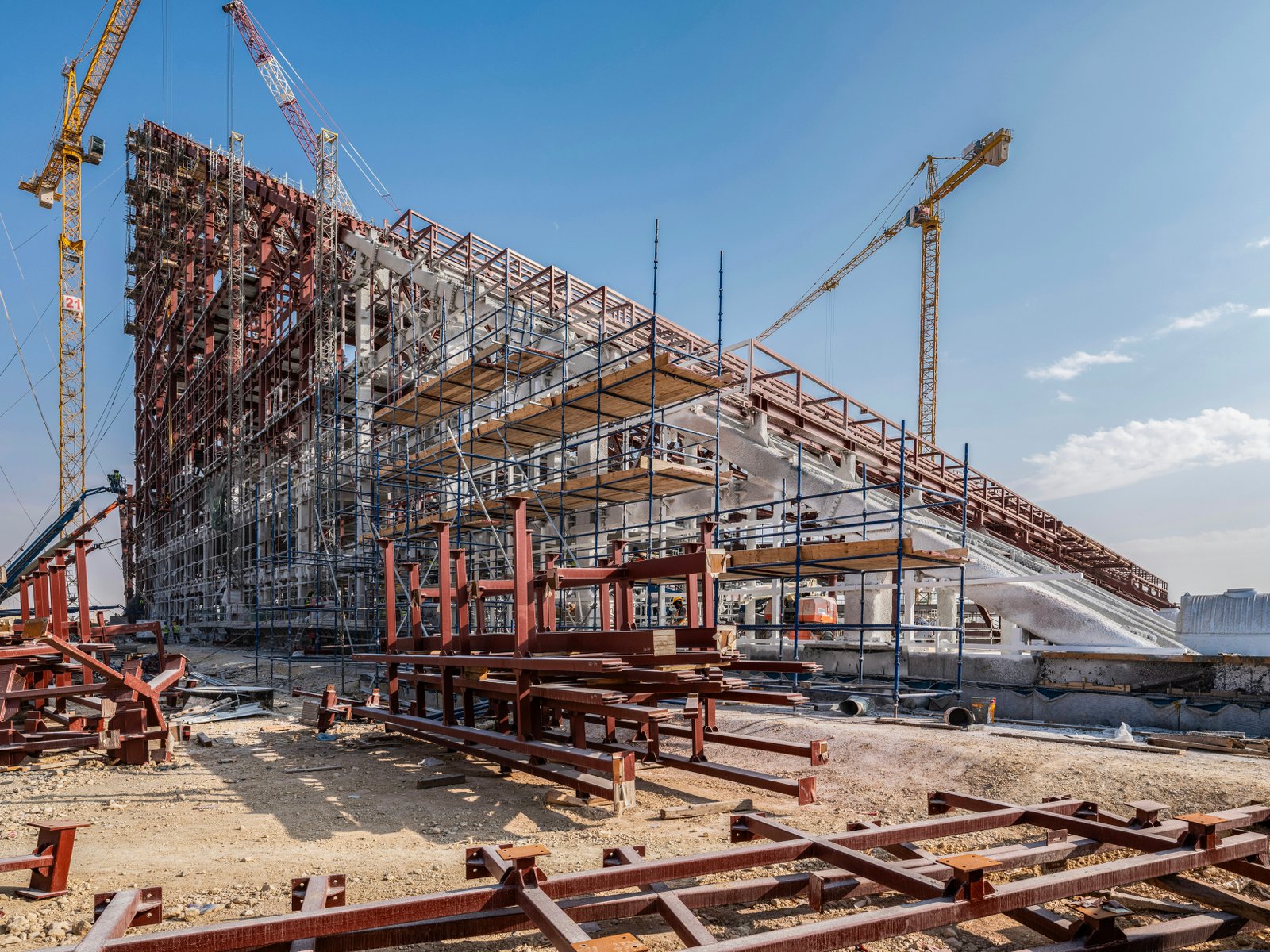 Large construction site with cranes and scaffolding in daylight open sky