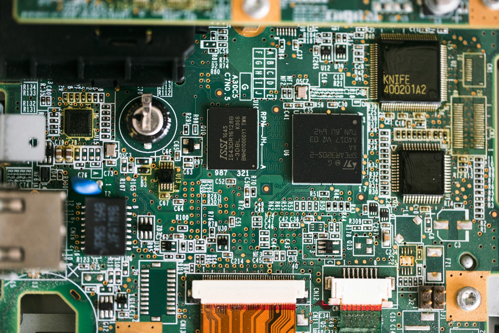 Circuit board macro photography with green LED lights in dark industrial setting